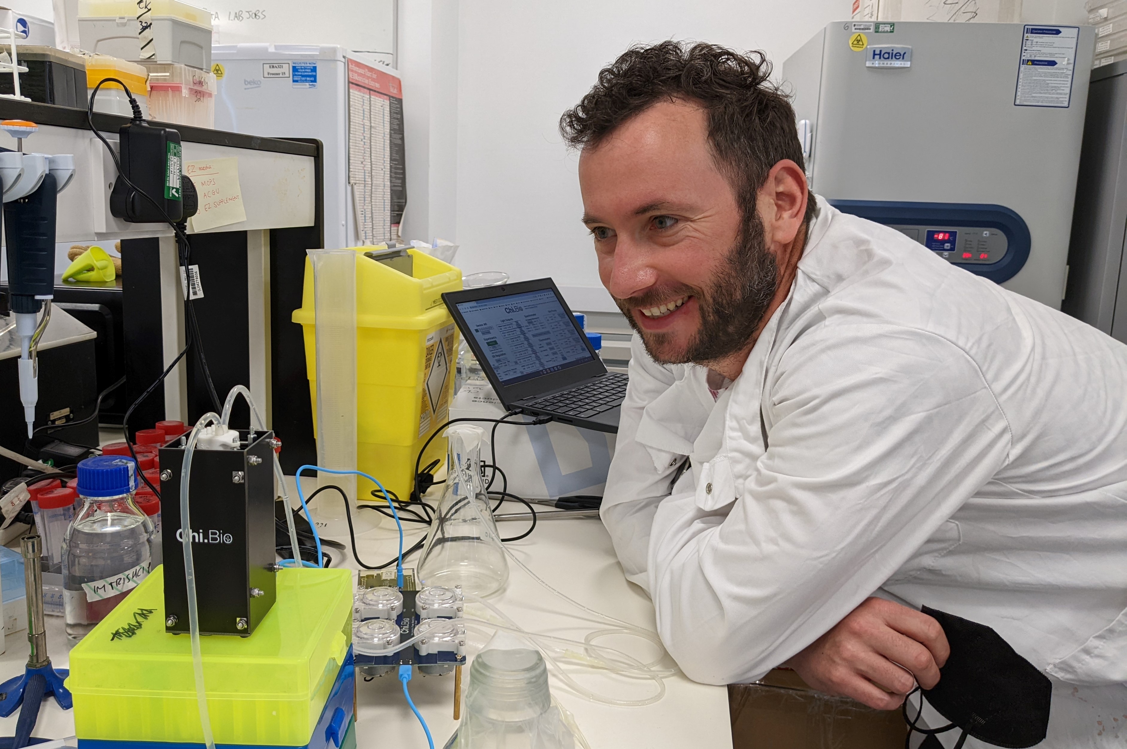 Ciarán Kelly in the lab, wearing a white lab coat